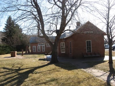The small red sandstone 1885 Lyons railroad depot with a bench by its door