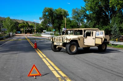 A National Guard Humvee at a road checkpoint in Lyons during the 2013 flood, warning triangle on the road