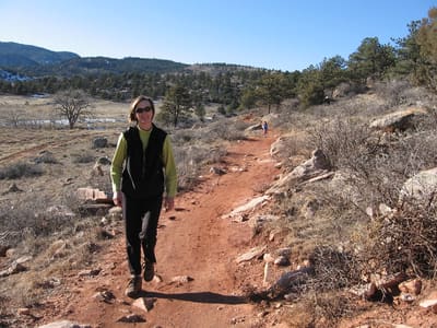 A hiker on the red-dirt Bitterbrush trail at Hall Ranch