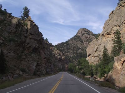 Colorado 7 winding between red sandstone walls in the South St. Vrain canyon under a blue sky