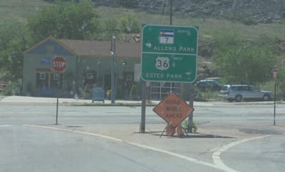 Highway signs at the Lyons junction pointing left for Colorado 7 north to Allenspark and right for US 36 west to Estes Park